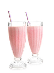 Glasses of milkshake with strawberries isolated on white