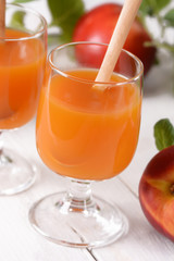 succo di pesca nel bicchiere di vetro con la frutta fresca intorno
