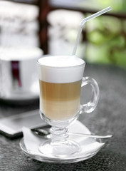 Glass of latte on table in cafe close-up