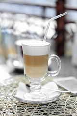 Glass of latte on table in cafe close-up