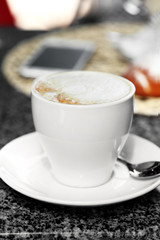 Cup of cappuccino on table in cafe