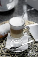 Glass of latte on table in cafe close-up