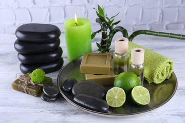 Beautiful composition of spa treatment on tray, on light background