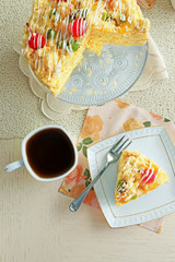 Peace of tasty Butter cake on plate, tea cups on color wooden background