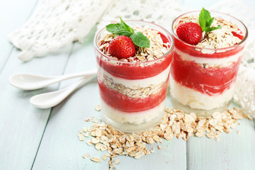 Dessert with fresh strawberry, cream and granola, on color wooden table background
