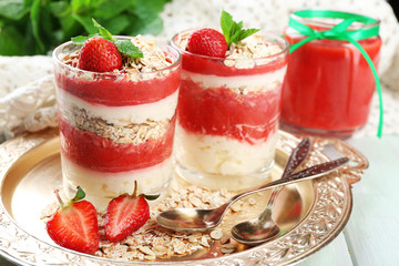 Dessert with fresh strawberry, cream and granola, on  tray, on wooden table background