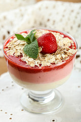 Dessert with fresh strawberry, cream and granola, on wooden table background