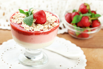 Dessert with fresh strawberry, cream and granola, on wooden table background