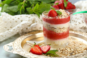 Dessert with fresh strawberry, cream and granola, on  tray, on wooden table background