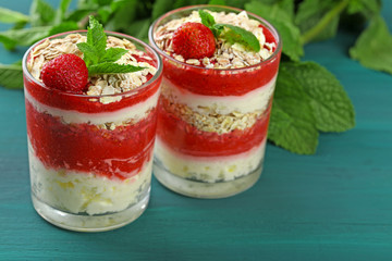 Dessert with fresh strawberry, cream and granola, on color wooden table background