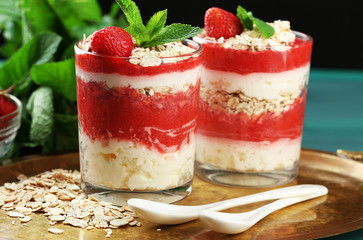Dessert with fresh strawberry, cream and granola, on tray, on color wooden table background