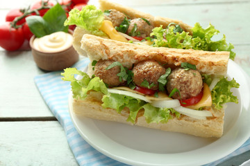 Homemade Spicy Meatball Sub Sandwich on plate, on wooden table background