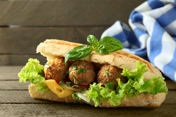 Homemade Spicy Meatball Sub Sandwich on wooden table background