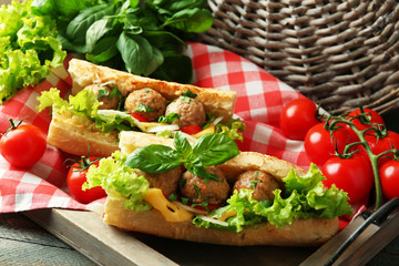Homemade Spicy Meatball Sub Sandwich on tray, on wooden table background
