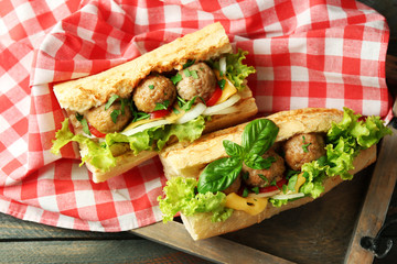 Homemade Spicy Meatball Sub Sandwich on tray, on wooden table background