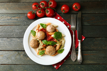 Pasta with meatballs on plate, on wooden  table background