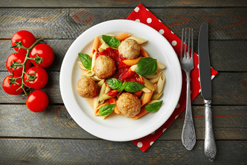 Pasta with meatballs on plate, on wooden  table background