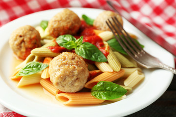 Pasta with meatballs on plate, on wooden  table background