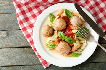 Pasta with meatballs on plate, on wooden  table background