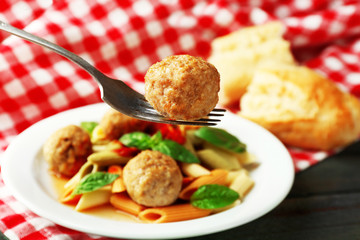 Pasta with meatballs on plate, on wooden  table background