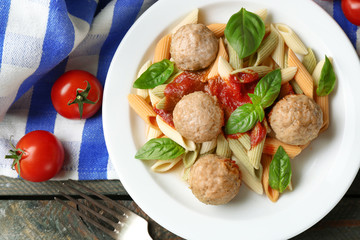 Pasta with meatballs on plate, on wooden  table background