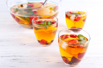 Fruity punch in glassware on wooden table, closeup