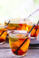 Fruity punch in glassware on metal tray, closeup