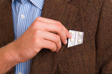 Man pulls medicine from his pocket in the jacket