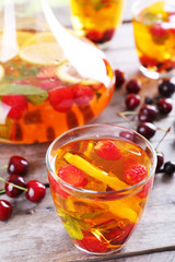 Punch with berries in glassware on wooden table, closeup