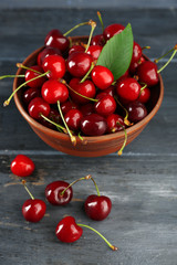 Fresh cherries in bowl on wooden background