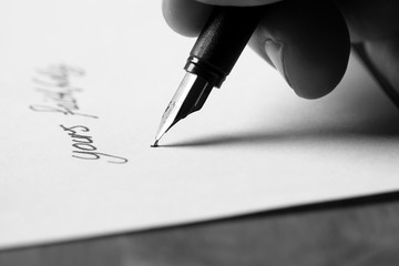 Signing letter fountain pen.
Man signing a letter using a fountain pen.