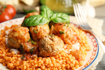 Meat balls with lentil and tomato sauce, wooden spoon on wooden background