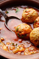 Meat balls with tomato sauce and wooden spoon, close-up