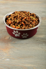 Dog food in bowl on wooden table