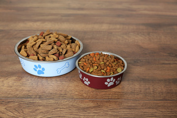 Dog food in bowls on floor at home