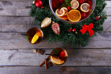 Sangria in bowl and glasses with Christmas decoration on wooden table close up