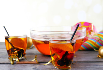 Sangria in bowl and glasses on light background