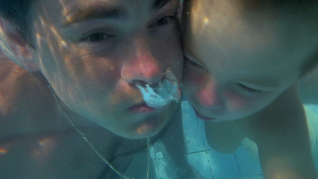 Father and son diving together in the pool