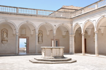 Obraz premium Courtyard Benedictine Monastery at Monte Cassino, a stone fountain and arcades