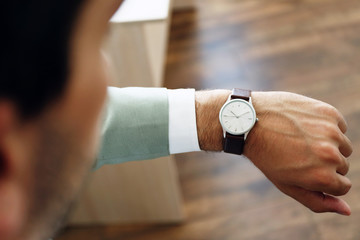 Businessman looking at his watch in office
