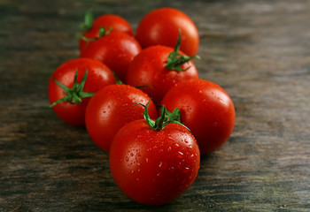 Pile of cherry tomatoes on wooden table close up