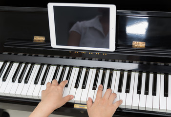 Fototapeta na wymiar Woman hand use tablet and playing piano music