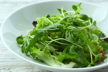 Fresh mixed green salad in bowl close up