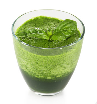 Glass of green vegetable juice with basil isolated on white