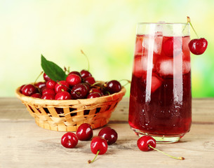 Glass of fresh juice with cherries on bright background