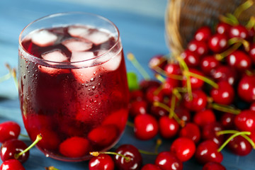 Glass of fresh juice with cherries on wooden table close up