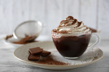 Cup of coffee with cream on color wooden background