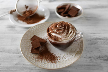 Cup of coffee with cream on color wooden background