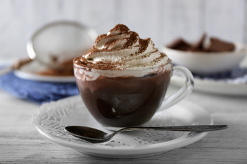 Cup of coffee with cream on color wooden background