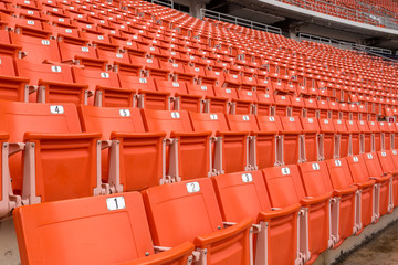 Fototapeta premium stadion, czerwone siedzenia na schodach stadionu, trybunka ze słupem oświetleniowym